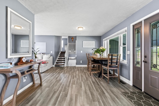 dining room featuring a textured ceiling and hardwood / wood-style floors