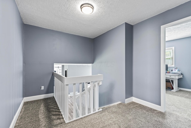 interior space with a textured ceiling and carpet