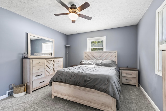 carpeted bedroom featuring a textured ceiling and ceiling fan