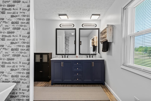 bathroom featuring a textured ceiling, a washtub, hardwood / wood-style floors, and vanity