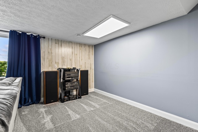 office featuring a textured ceiling, wooden walls, and carpet flooring