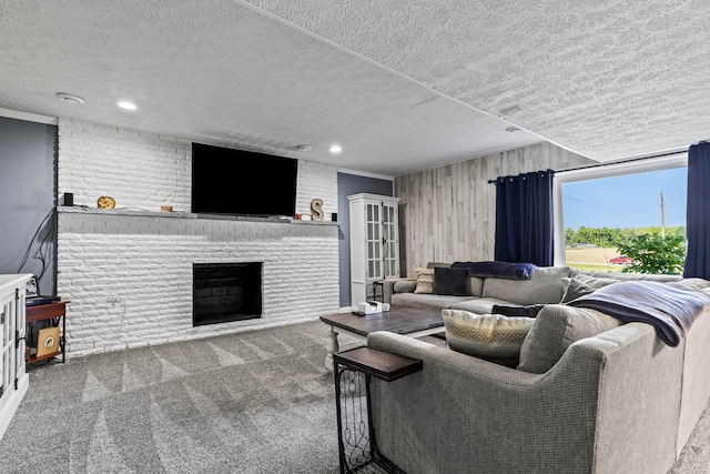 living room with wooden walls, a fireplace, a textured ceiling, and carpet floors