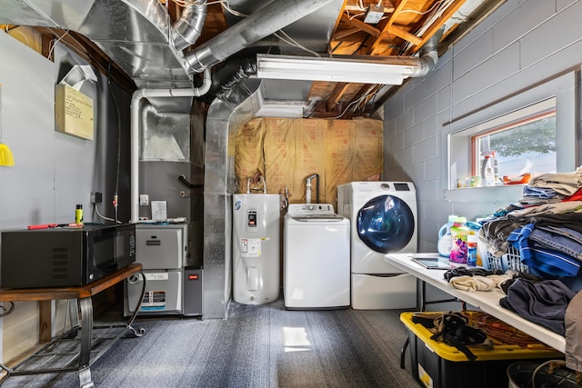 clothes washing area featuring water heater and washing machine and clothes dryer