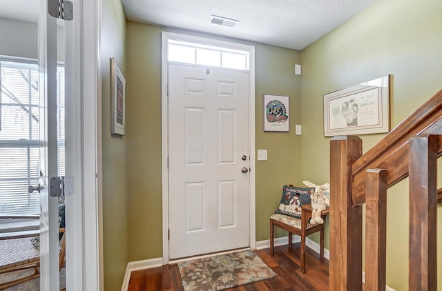 entryway featuring a textured ceiling and dark hardwood / wood-style floors