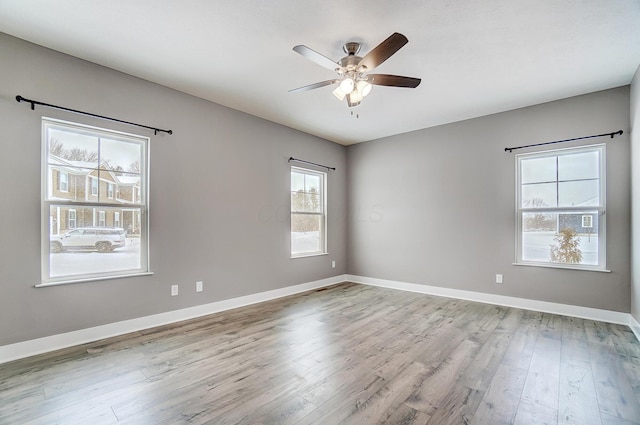 empty room featuring light wood-type flooring, ceiling fan, and plenty of natural light