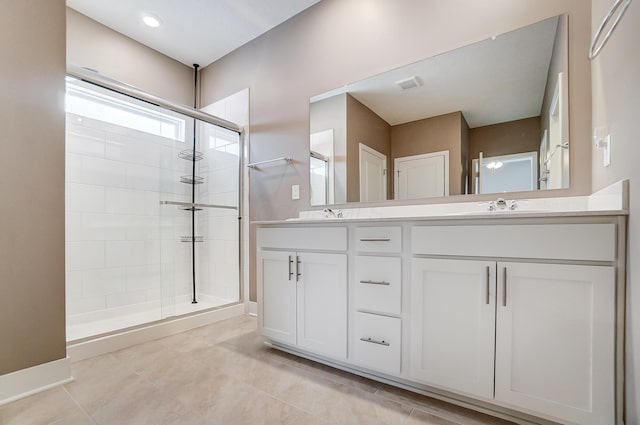 bathroom with an enclosed shower, vanity, and tile patterned flooring