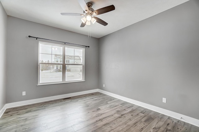 empty room with ceiling fan and light hardwood / wood-style floors