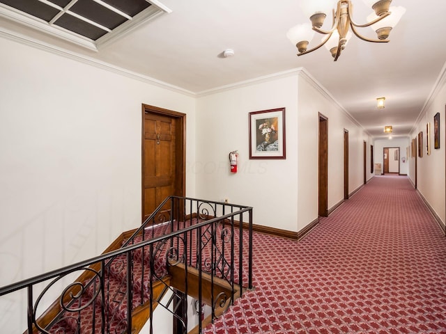 hallway featuring carpet, crown molding, and a notable chandelier