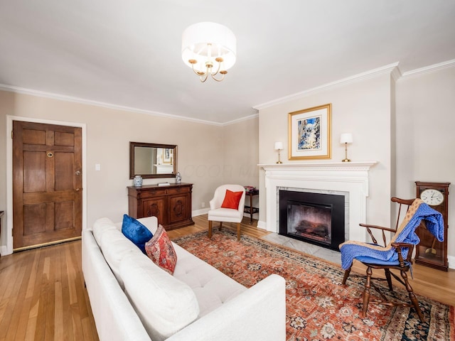 living room featuring a notable chandelier, crown molding, and light hardwood / wood-style floors