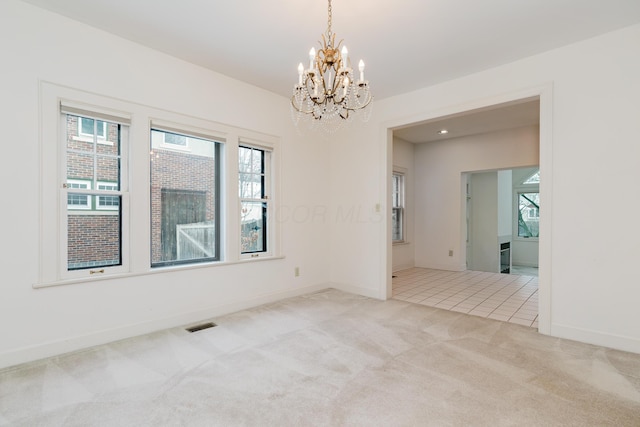 unfurnished room featuring light carpet and a chandelier