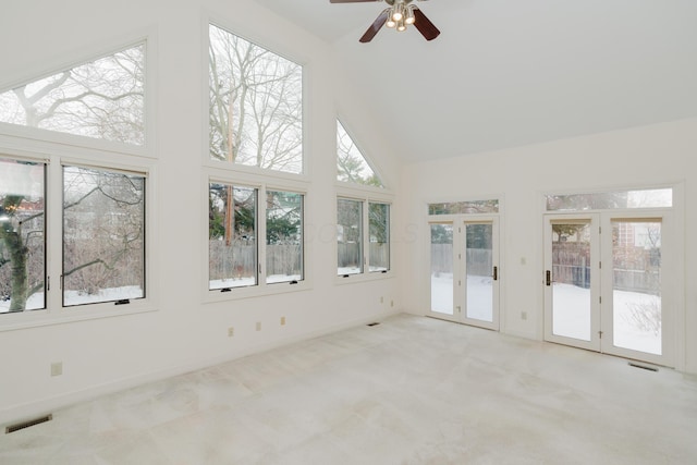 unfurnished sunroom with vaulted ceiling, ceiling fan, a wealth of natural light, and french doors