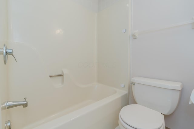 bathroom featuring bathtub / shower combination and toilet