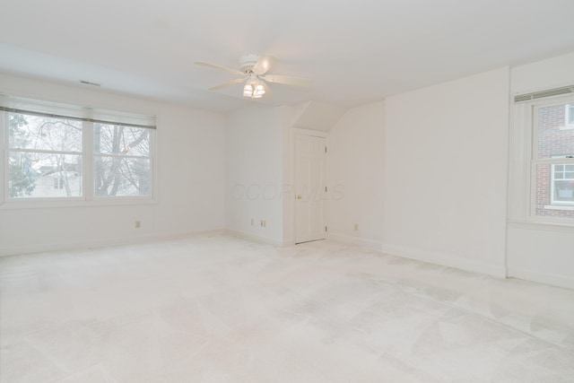 carpeted spare room featuring ceiling fan