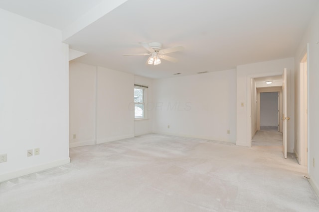 empty room featuring ceiling fan and light colored carpet