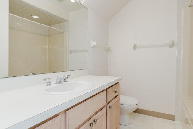 bathroom featuring toilet, vanity, and a shower