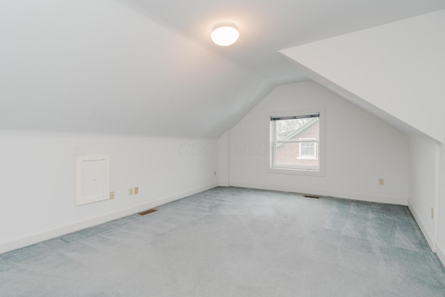 additional living space with vaulted ceiling and light carpet