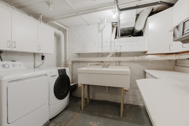 washroom with cabinets, sink, and washing machine and dryer