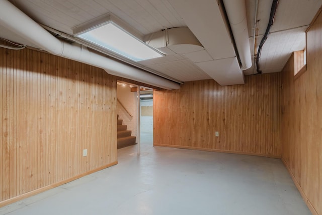 basement featuring wooden walls