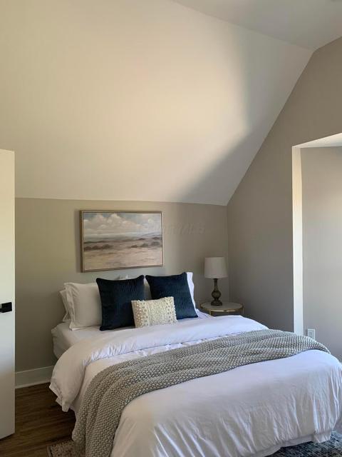 bedroom featuring lofted ceiling and dark wood-type flooring