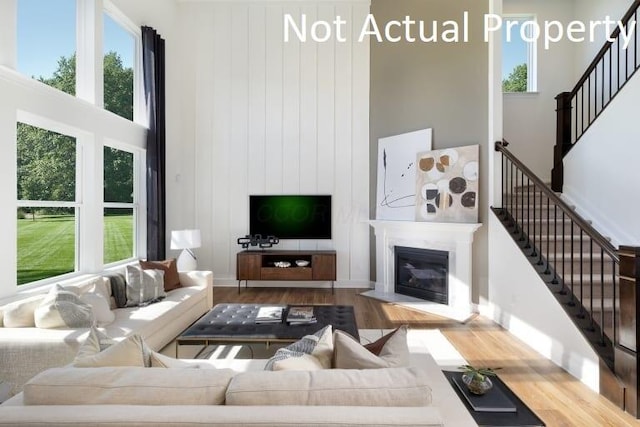 living room featuring a towering ceiling and hardwood / wood-style flooring