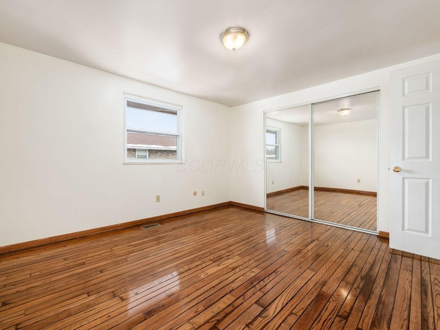 unfurnished bedroom with a closet and hardwood / wood-style flooring