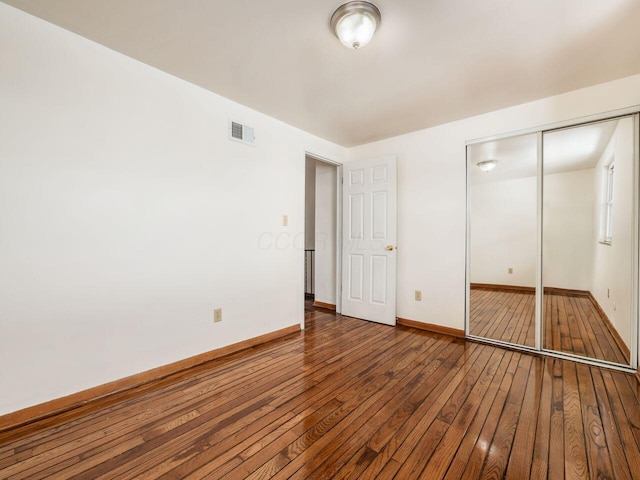 unfurnished bedroom with a closet and hardwood / wood-style floors