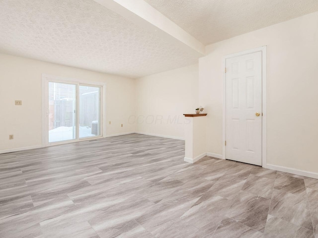 unfurnished room with a textured ceiling