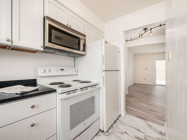 kitchen featuring electric range, white cabinetry, and a textured ceiling