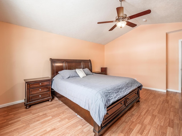 bedroom with ceiling fan, light hardwood / wood-style flooring, and vaulted ceiling