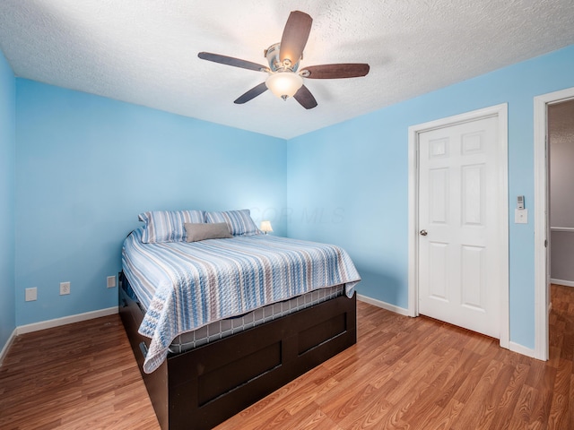 bedroom featuring ceiling fan, a textured ceiling, and hardwood / wood-style flooring