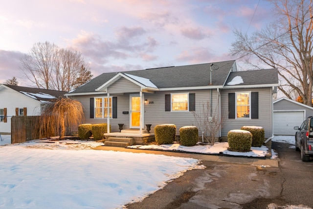 ranch-style home featuring a garage and an outbuilding