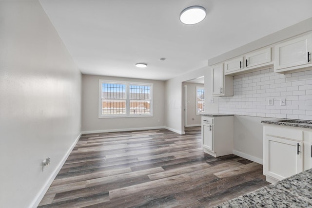 kitchen featuring backsplash, white cabinetry, dark hardwood / wood-style floors, and stone counters