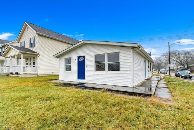 rear view of property with a porch and a yard