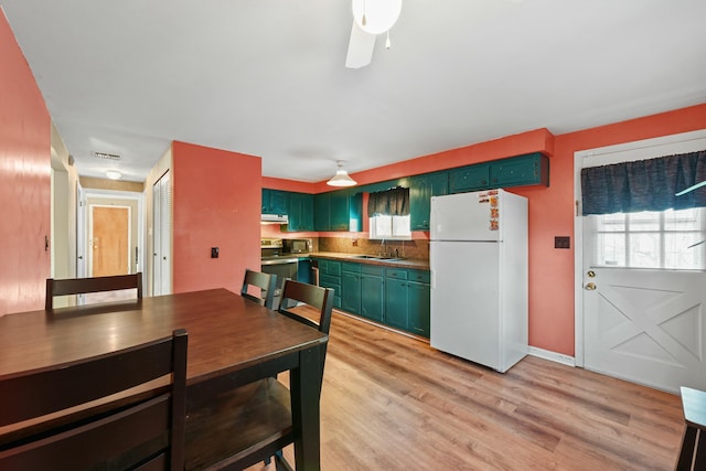 dining area featuring sink, ceiling fan, a healthy amount of sunlight, and light hardwood / wood-style floors