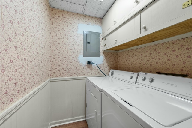 laundry room featuring electric panel, cabinets, and washer and clothes dryer