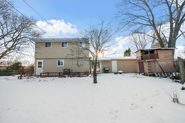 snow covered house featuring central AC unit