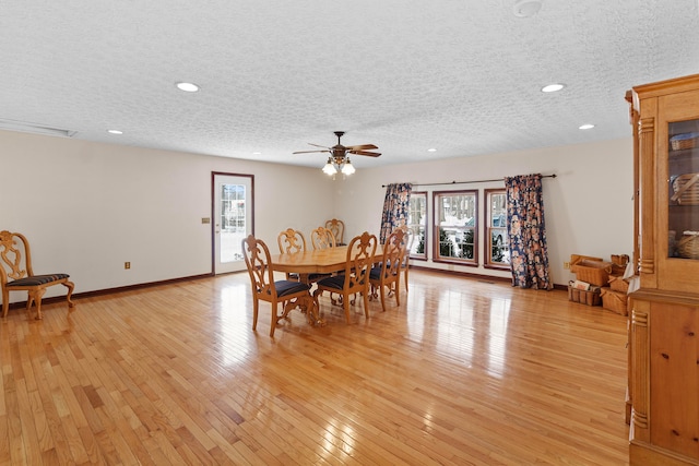 dining area featuring light hardwood / wood-style floors, a textured ceiling, ceiling fan, and a wealth of natural light