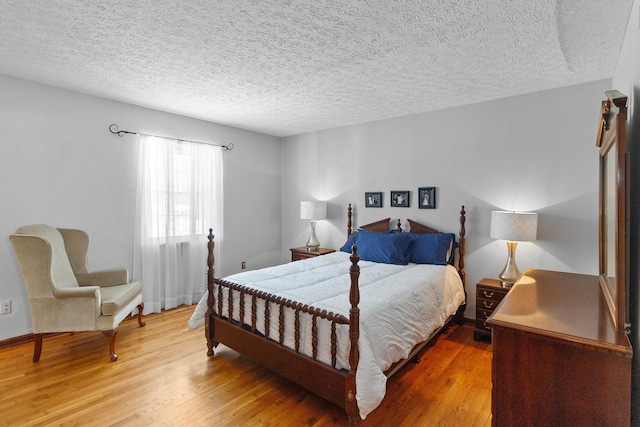 bedroom with wood-type flooring and a textured ceiling