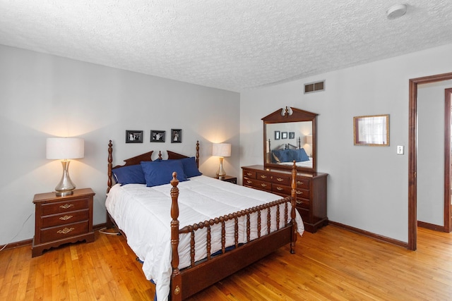 bedroom featuring a textured ceiling and light hardwood / wood-style flooring