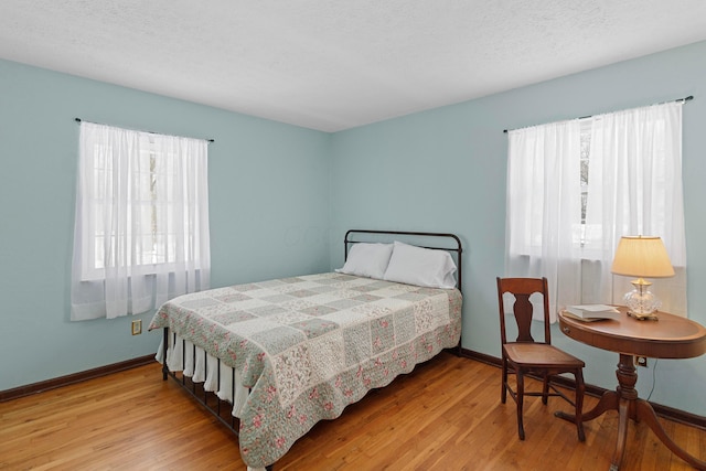 bedroom featuring a textured ceiling and light hardwood / wood-style floors