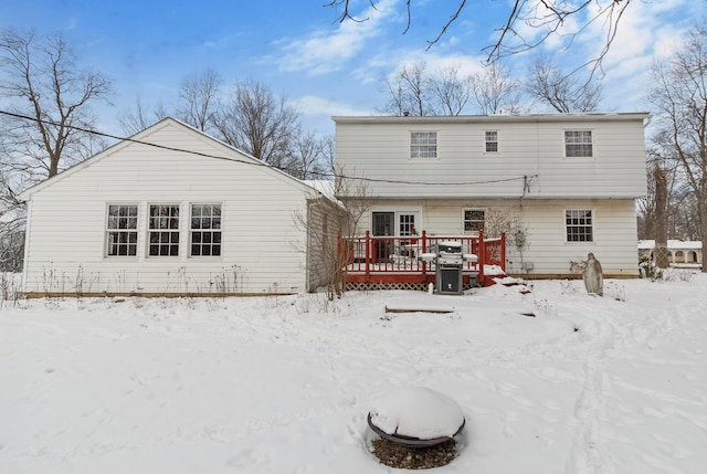 snow covered rear of property featuring a wooden deck