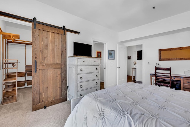 bedroom featuring light colored carpet, a closet, and a barn door