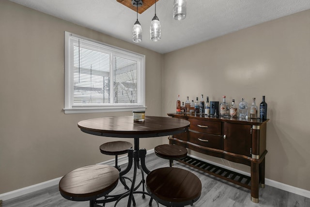 dining room featuring a textured ceiling and light hardwood / wood-style flooring