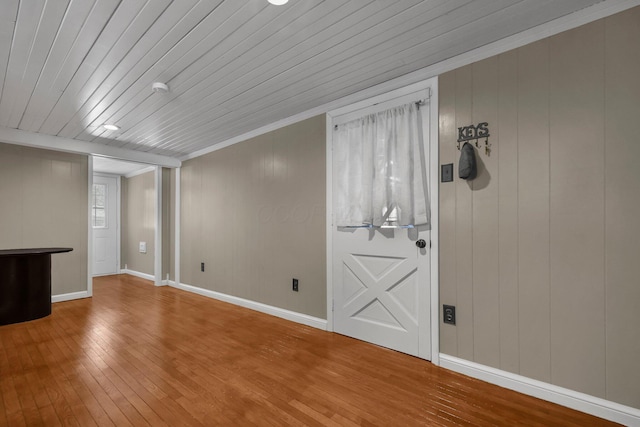 empty room with ornamental molding, wooden ceiling, and hardwood / wood-style floors