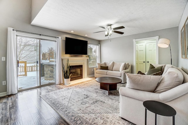 living room featuring hardwood / wood-style floors, a textured ceiling, ceiling fan, and a healthy amount of sunlight