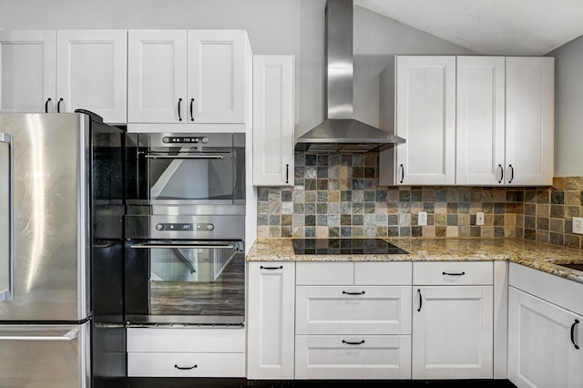 kitchen with white cabinets, wall chimney range hood, tasteful backsplash, and appliances with stainless steel finishes