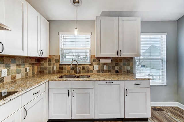 kitchen with sink, white cabinets, plenty of natural light, and hanging light fixtures