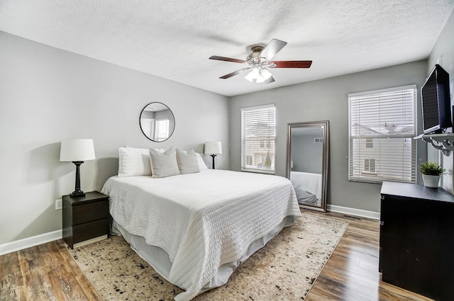 bedroom featuring a textured ceiling, ceiling fan, and dark hardwood / wood-style flooring