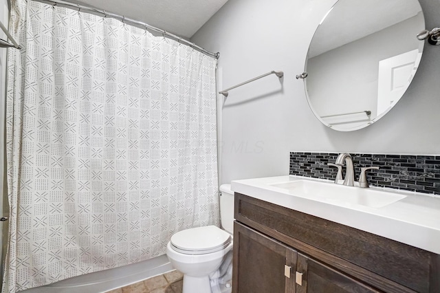 bathroom with toilet, vanity, and decorative backsplash