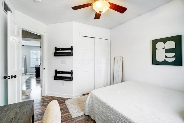 bedroom with ceiling fan, a closet, and dark hardwood / wood-style floors